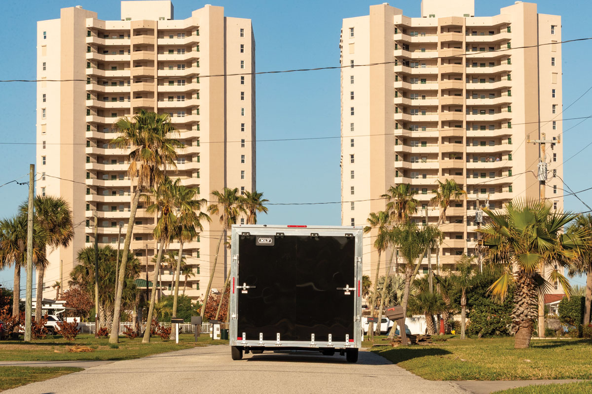 Rear view of black XLT Pro car hauler driving down town